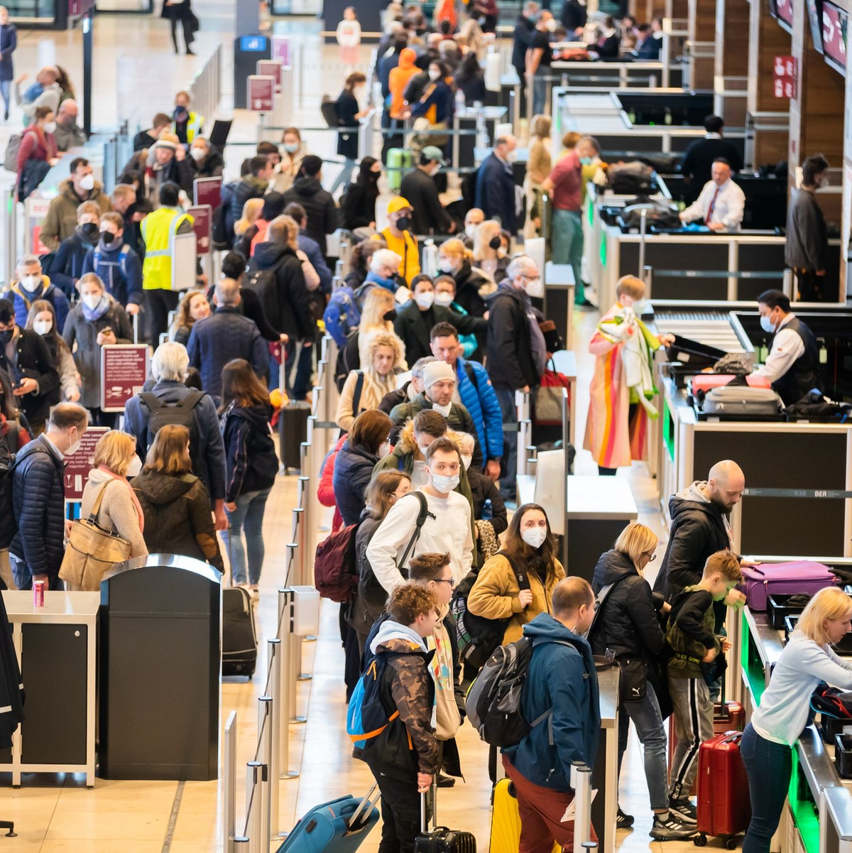 Passagiere stehen am Flughafen Berlin Brandenburg „Willy Brandt“ (BER) vor der Sicherheitskontrolle Schlange. - Foto: Christoph Soeder/dpa