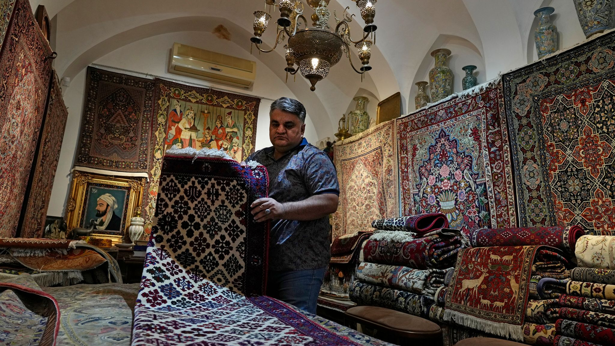 Ein iranischer Teppichhändler arbeitet in seinem Geschäft auf dem traditionellen Basar der Stadt Kashan. - Foto: Vahid Salemi/AP/dpa