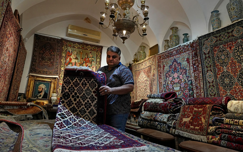 Ein iranischer Teppichhändler arbeitet in seinem Geschäft auf dem traditionellen Basar der Stadt Kashan. - Foto: Vahid Salemi/AP/dpa