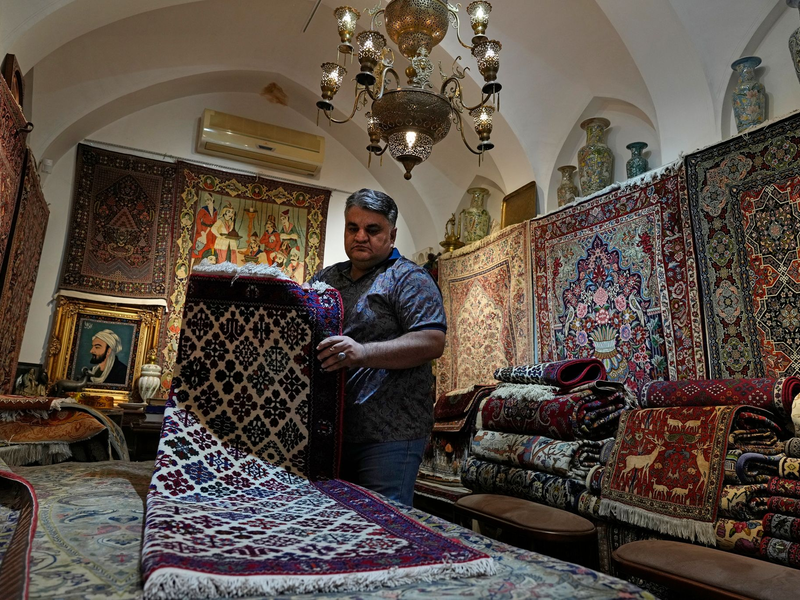 Ein iranischer Teppichhändler arbeitet in seinem Geschäft auf dem traditionellen Basar der Stadt Kashan. - Foto: Vahid Salemi/AP/dpa