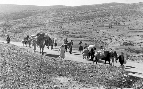 Arabische Flüchtlinge gehen mit ihren Kindern und Habseligkeiten im Gepäck am 9. November 1948 auf einer staubigen Straße von Jerusalem in den Libanon. Die Staatsgründung Israels war 1948 für Hunderttausende von Palästinensern mit Vertreibung und dem Verlust von Heimat verbunden. - Foto: Jim Pringle/AP/dpa