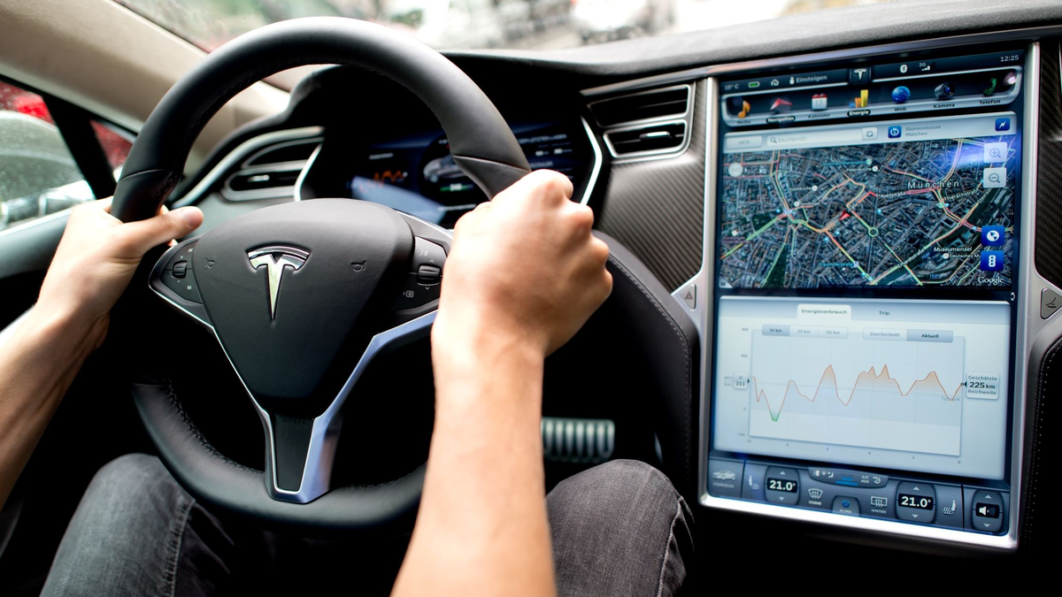 Ein Mann sitzt in einem Tesla Model S am Lenkrad: Elon Musk sagt, er sei mit seinen Versprechen zu selbstfahrenden Autos oft zu optimistisch gewesen. - Foto: Sven Hoppe/dpa