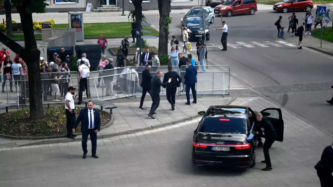 Leibwächter bringen den slowakischen Regierungschef Robert Fico nach dem Attentat in einem Auto in Sicherheit. - Bild: Radovan Stoklasa/TASR/dpa
