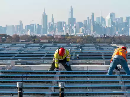 Elektriker installieren im New Yorker Stadtteil Queens Solarpaneele. Die US-Regierung hebt Zoll-Ausnahmen für bestimmte Solar-Importe auf. - Foto: Mary Altaffer/AP/dpa