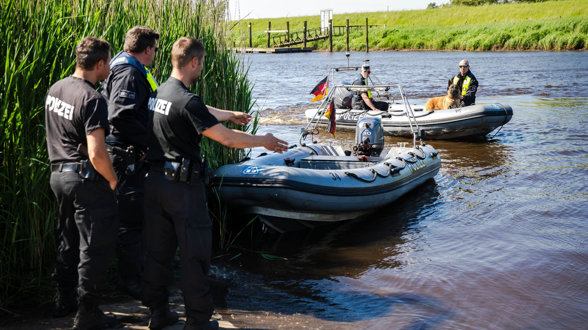Einsatzkräfte der Polizei fahren bei der Suche nach dem vermissten Arian mit Spürhunden auf Schlauchbooten über die Oste. - Foto: Sina Schuldt/dpa