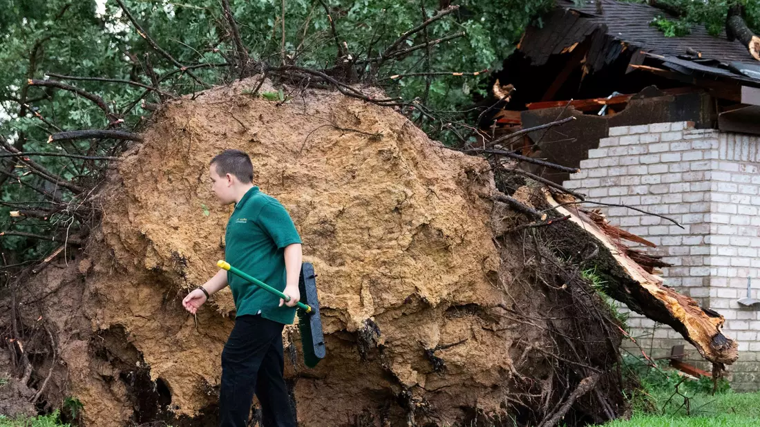 Ein entwurzelter Baum, der auf ein Haus gestürzt ist, nachdem starker Wind und Regen über Houston hinweggefegt waren. - Bild: Jason Fochtman/Houston Chronicle/AP/dpa
