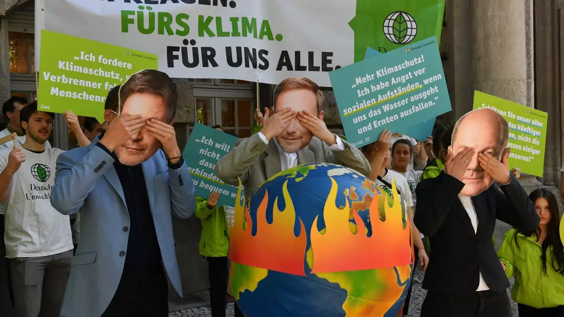 Aktivisten der Deutschen Umwelthilfe (DUH) protestieren vor dem Oberverwaltungsgericht Berlin. Oberverwaltungsgerichtes für das Klimaschutz-Urteil. - Bild: Paul Zinken/dpa