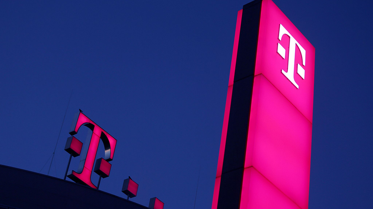 Das Logo der Deutschen Telekom leuchtet auf dem Dach der Unternehmenszentrale. - Foto: Oliver Berg/dpa