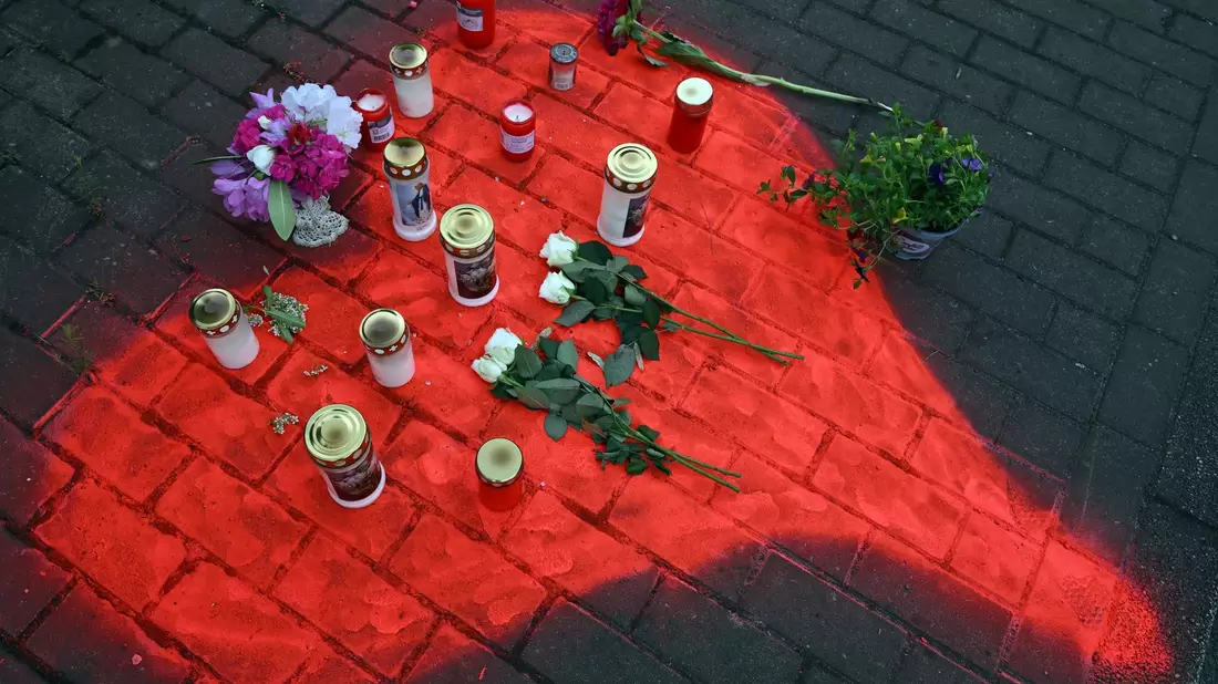 Kerzen und Blumen liegen in einem auf das Pflaster gesprühten roten Herzen in Düsseldorf nach dem mörderischen Brandanschlag. - Bild: Federico Gambarini/dpa