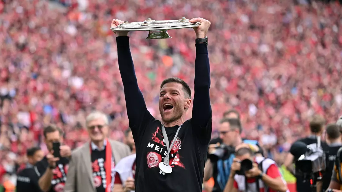 Xabi Alonso jubelt mit der Meisterschale in der Kurve. - Bild: Marius Becker/dpa