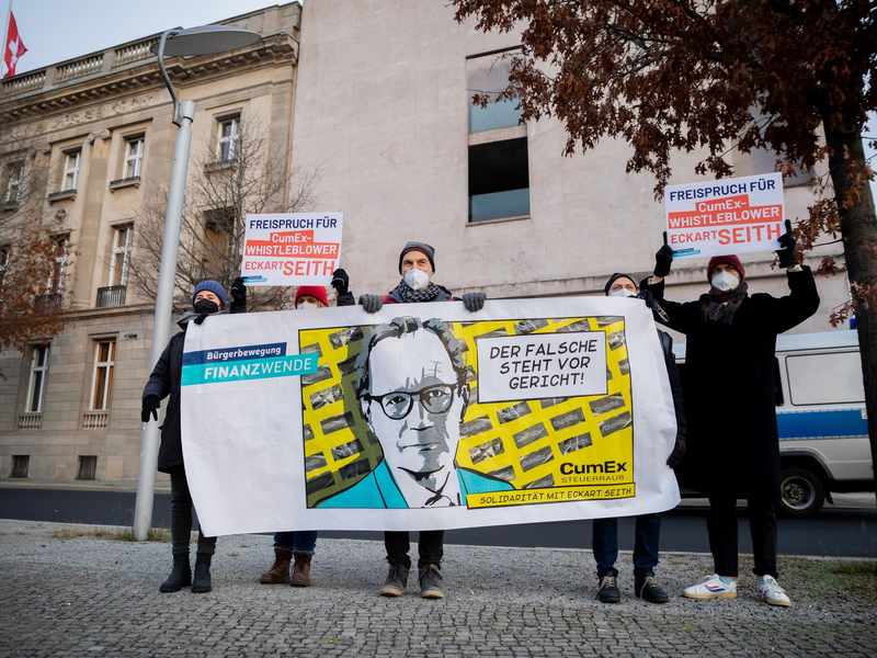 Gerhard Schick (M) nimmt an einer Solidaritätsaktion der Bürgerbewegung Finanzwende für CumEx-Hinweisgeber Eckart Seith teil. - Foto: Christoph Soeder/dpa