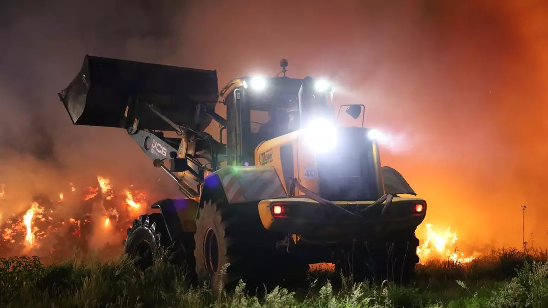 FW Hambühren: Strohmiete mit rund 100 Ballen brennt bei aktuell hoher Waldbrandgefahr mitten in Waldgebiet nieder / Stundenlanger Löscheinsatz mit schwerem Gerät verhindert Übergreifen des Brandes - Bild: presseportal.de