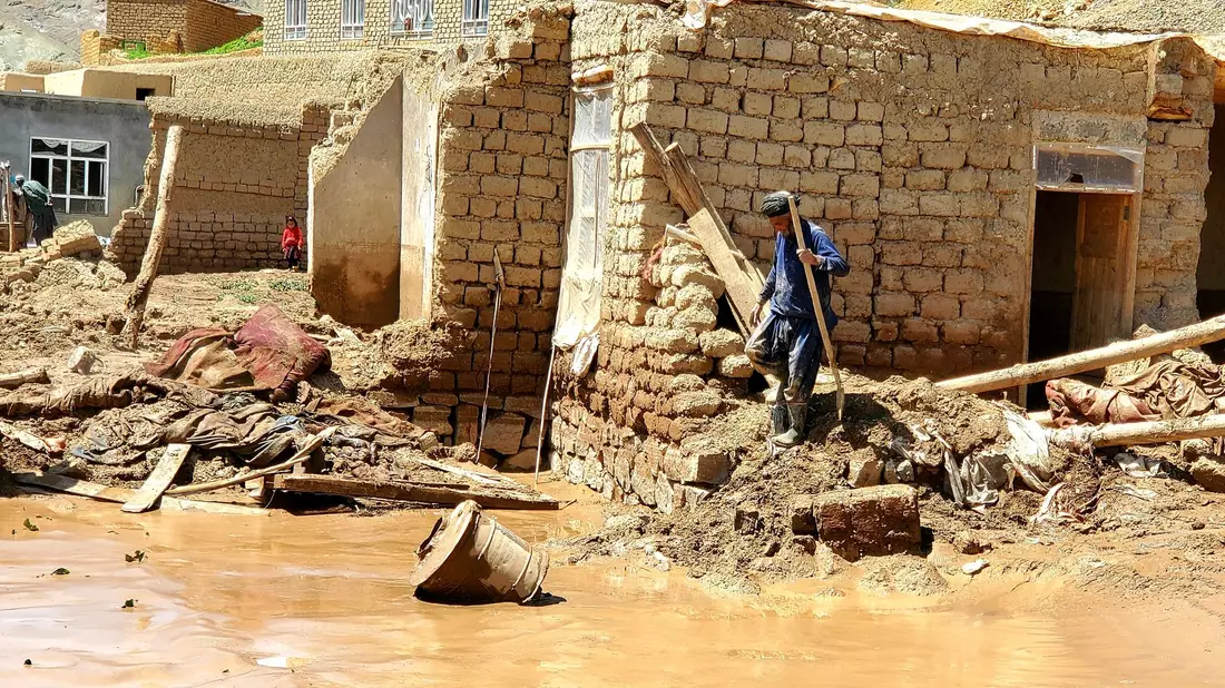 Ein Mann sammelt nach schweren Überschwemmungen in der Provinz Ghor seine Habseligkeiten zusammen. - Bild: Omid Haqjoo/AP/dpa