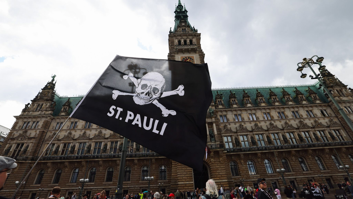 Fans des FC St. Pauli sammeln sich für die Aufstiegsfeier auf dem Rathausmarkt vor dem Rathaus. - Foto: Christian Charisius/dpa