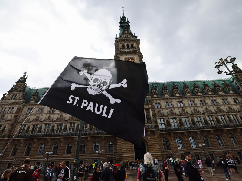Fans des FC St. Pauli sammeln sich für die Aufstiegsfeier auf dem Rathausmarkt vor dem Rathaus. - Foto: Christian Charisius/dpa