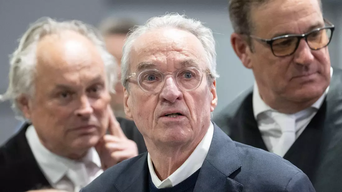 Zum Prozessauftakt gegen die mutmaßliche «Reichsbürger»-Gruppe steht der Hauptangeklagte Heinrich XIII. Prinz Reuß (M) zwischen seinen Verteidigern im Gerichtssaal. - Bild: Boris Roessler/dpa-Pool/dpa