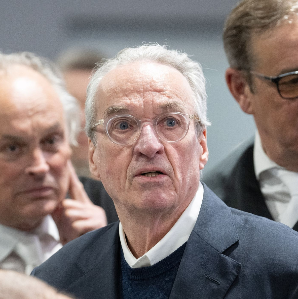 Zum Prozessauftakt gegen die mutmaßliche «Reichsbürger»-Gruppe steht der Hauptangeklagte Heinrich XIII. Prinz Reuß (M) zwischen seinen Verteidigern im Gerichtssaal. - Foto: Boris Roessler/dpa-Pool/dpa