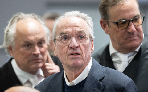 Zum Prozessauftakt gegen die mutmaßliche «Reichsbürger»-Gruppe steht der Hauptangeklagte Heinrich XIII. Prinz Reuß (M) zwischen seinen Verteidigern im Gerichtssaal. - Foto: Boris Roessler/dpa-Pool/dpa
