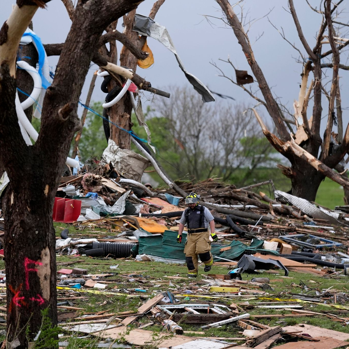 Ein Feuerwehrmann geht in Greenfield, Iowa, durch die Trümmer von Häusern, die vo einem Tornado zerstört wurden. - Foto: Charlie Neibergall/AP/dpa