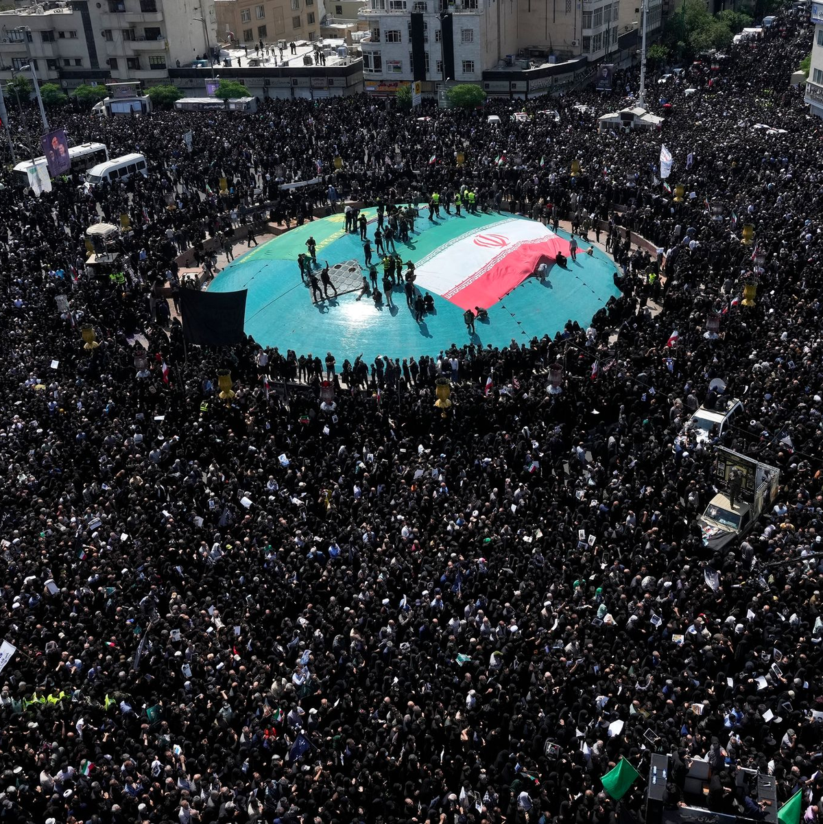 Frauen erinnern mit Plakaten an den verstorbenen Präsidenten. - Foto: Vahid Salemi/AP/dpa