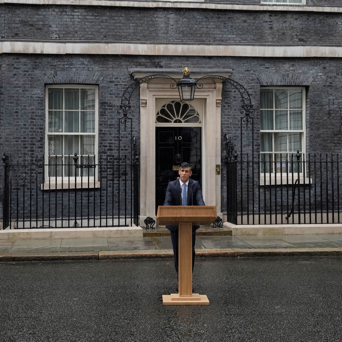 Steht im Regen und kündigt Neuwahlen an: Premierminister Rishi Sunak. - Foto: Kin Cheung/AP/dpa