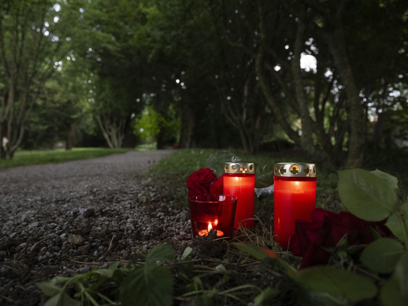 Blumem und Kerzen liegen im Park an dem Tatort im schweizerischen Männedorf. - Foto: Ennio Leanza/KEYSTONE/dpa