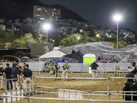 Sicherheitskräfte stehen um die Bühne, die zusammengebrochen ist. - Foto: Alberto Lopez/AP/dpa