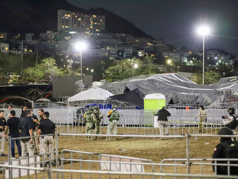 Sicherheitskräfte stehen um die Bühne, die zusammengebrochen ist. - Foto: Alberto Lopez/AP/dpa