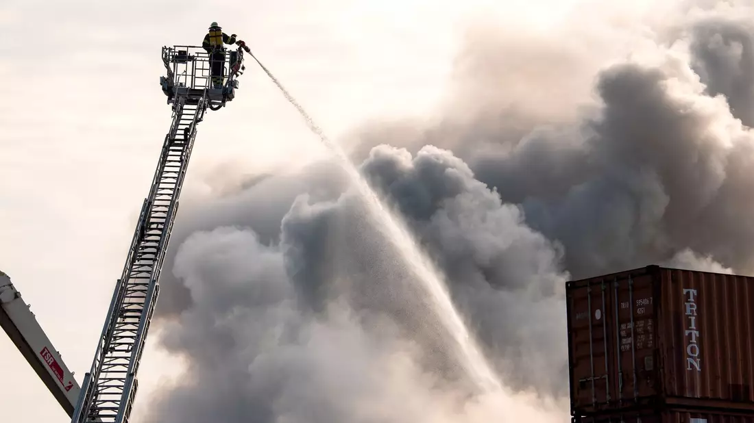 Die Feuerwehr kämpft im Hamburger Hafen gegen das Feuer. - Bild: Daniel Bockwoldt/dpa/Daniel Bockwoldt