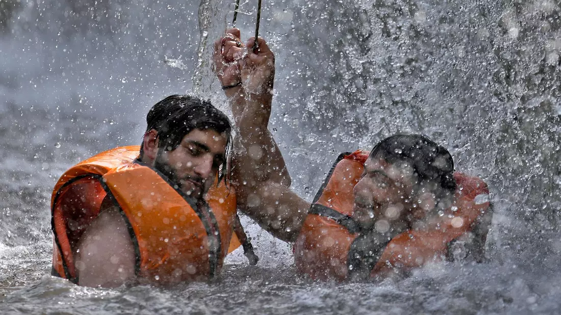 Zwei pakistanische Männer kühlen sich in Islamabad in einem Bach ab. - Bild: Anjum Naveed/AP/dpa