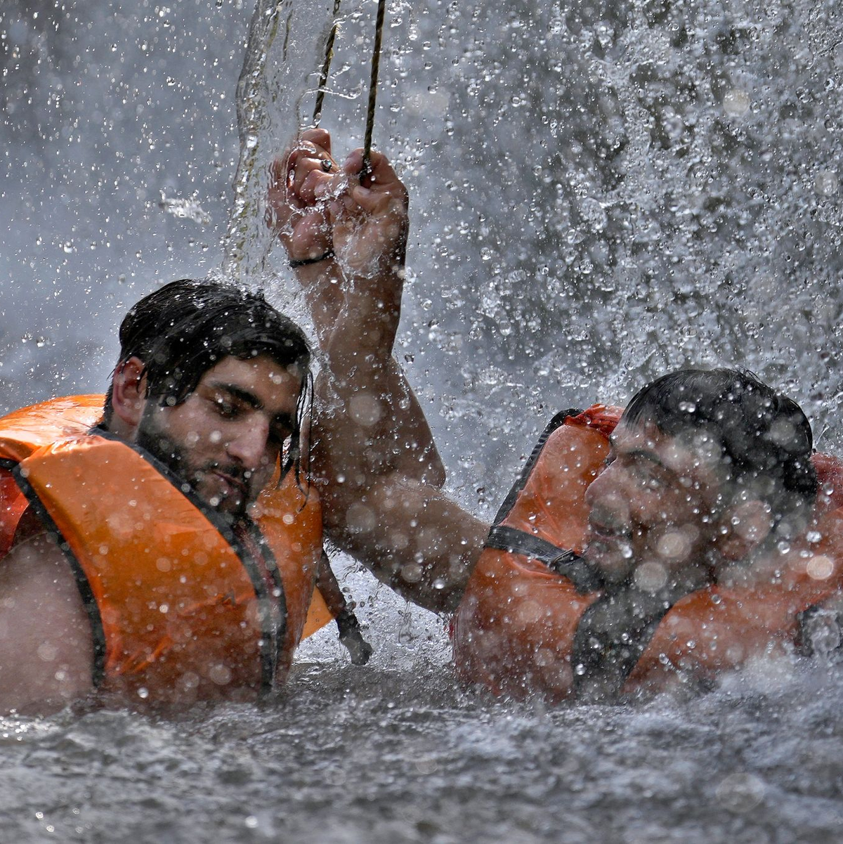 Pakistanische Männer kühlen sich in einem Bach ab, während die Temperaturen in Islamabad 39 Grad Celsius erreichen. - Foto: Anjum Naveed/AP/dpa