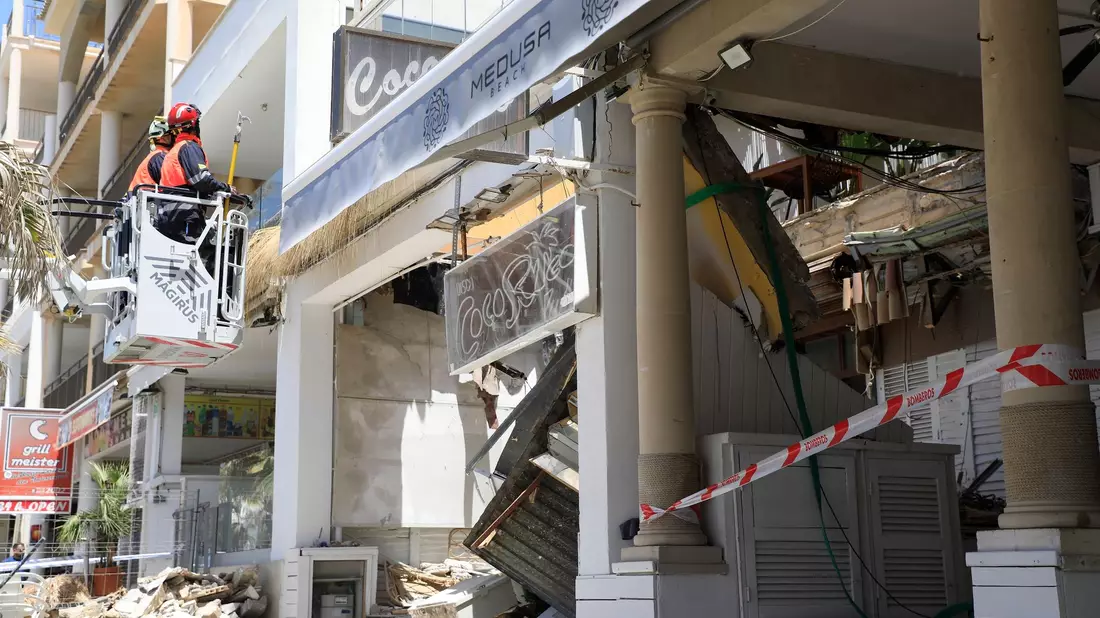 Feuerwehrleute arbeiten nach dem Einsturz am Gebäude des Medusa Beach Club auf Mallorca. - Bild: Clara Margais/dpa