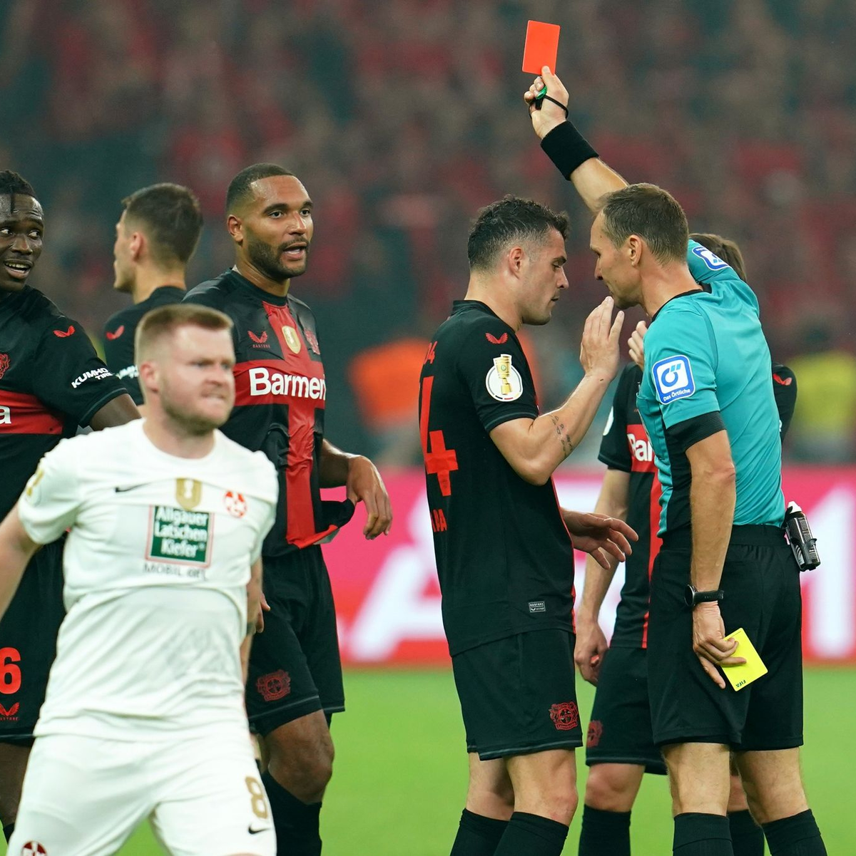 Bayer-Verteidiger Odilon Kossounou (l) sah noch vor der Pause die Gelb-Rote Karte. - Foto: Uwe Anspach/dpa