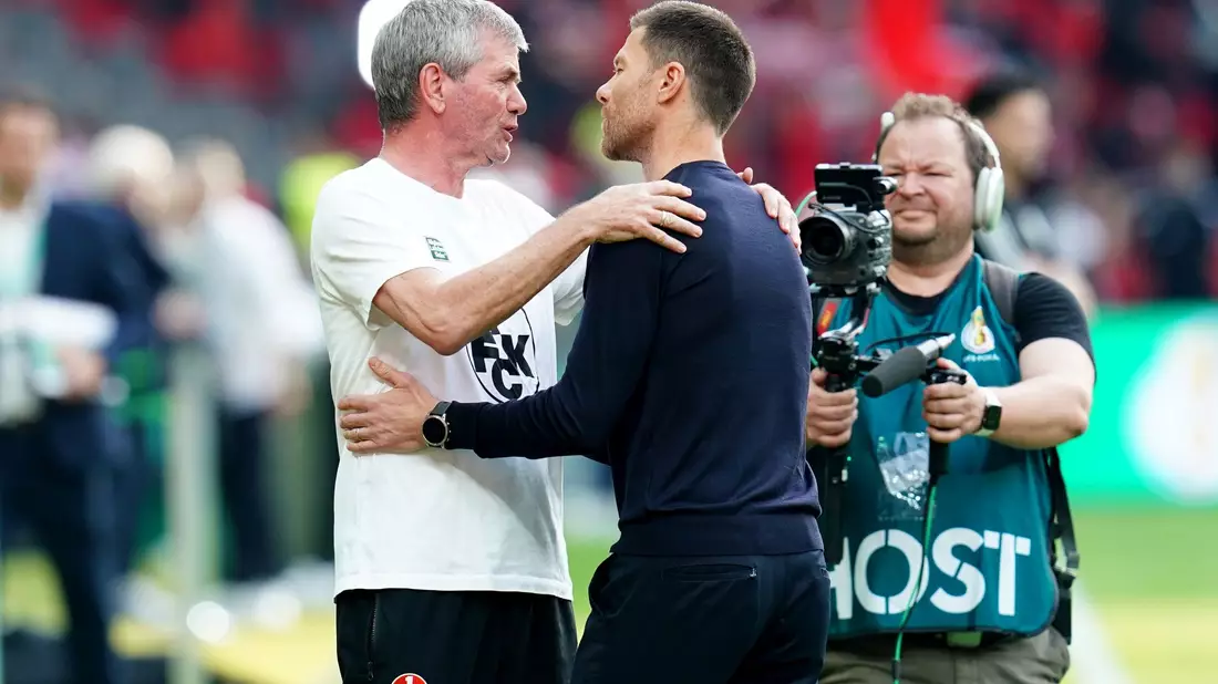 Kaiserslauterns Trainer Friedhelm Funkel (l) und Bayer-Coach Xabi Alonso begrüßen sich vor der Partie. - Bild: Uwe Anspach/dpa