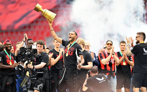 Leverkusens Jonathan Tah (M) präsentiert bei der Meisterfeier in der BayArena die Meisterschale und den Pokal. - Foto: Marius Becker/dpa