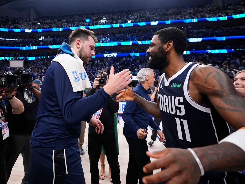 Mavericks-Guards Luka Doncic (l) und Kyrie Irving feiern den Sieg. - Foto: Julio Cortez/AP/dpa