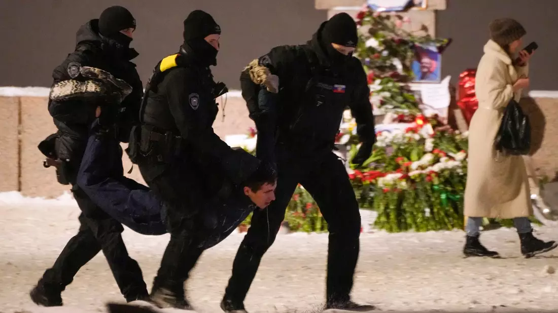 Polizeibeamte halten einen Mann fest, der Blumen zu Ehren von Alexej Nawalny an einem Denkmal für die Opfer der sowjetischen Unterdrückung in St. Petersburg niedergelegt hat. - Bild: Uncredited/AP/dpa