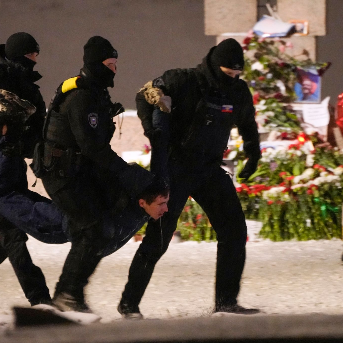 Polizeibeamte halten einen Mann fest, der Blumen zu Ehren von Alexej Nawalny an einem Denkmal für die Opfer der sowjetischen Unterdrückung in St. Petersburg niedergelegt hat. - Foto: Uncredited/AP/dpa