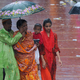 Fußgängerinnen gehen in Bangladesh durch den Regen. - Foto: Md Rafayat Haque Khan/ZUMA Press Wire/dpa