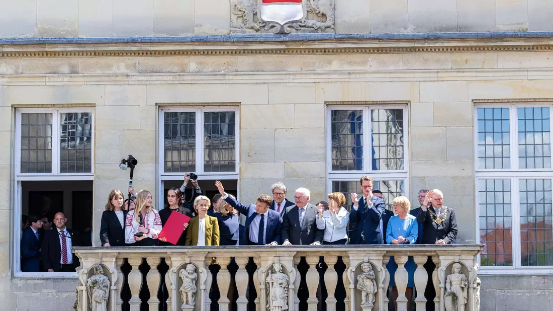 Der französische Präsident Emmanuel Macron winkt der Menge vom Balkon des Stadtweinhauses zu. - Bild: Guido Kirchner/dpa