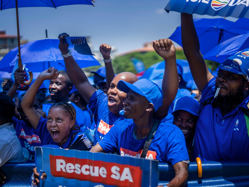 Anhänger der südafrikanischen Oppositionspartei Democratic Alliance (DA) versammeln sich zur Vorstellung ihres nationalen Wahlprogramms im Vorfeld der Parlamentswahlen 2024. - Foto: Jerome Delay/AP/dpa
