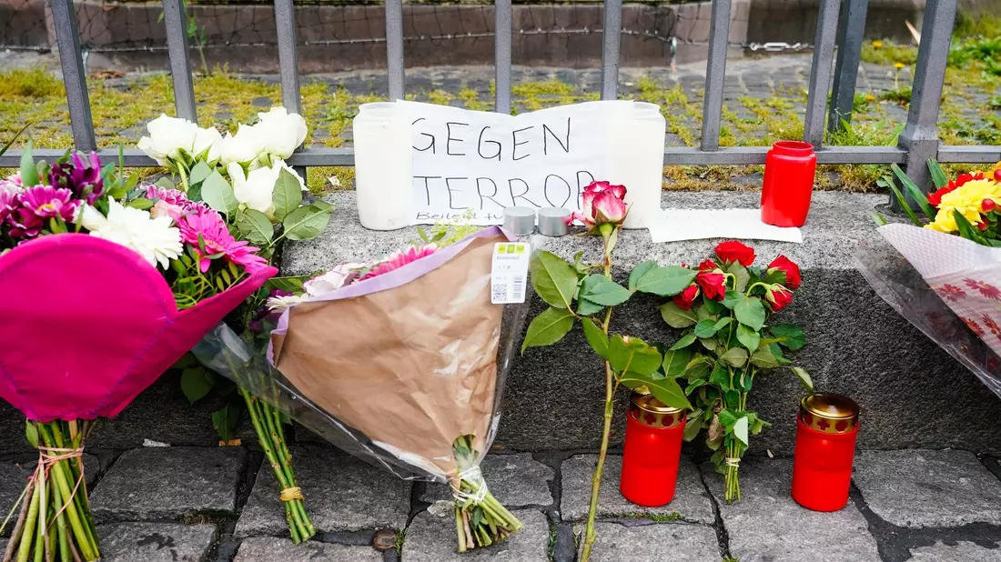 Mitarbeiter der Spurensicherung stehen auf dem Marktplatz hinter einem zertrümmerten Stand. - Bild: Uwe Anspach/dpa