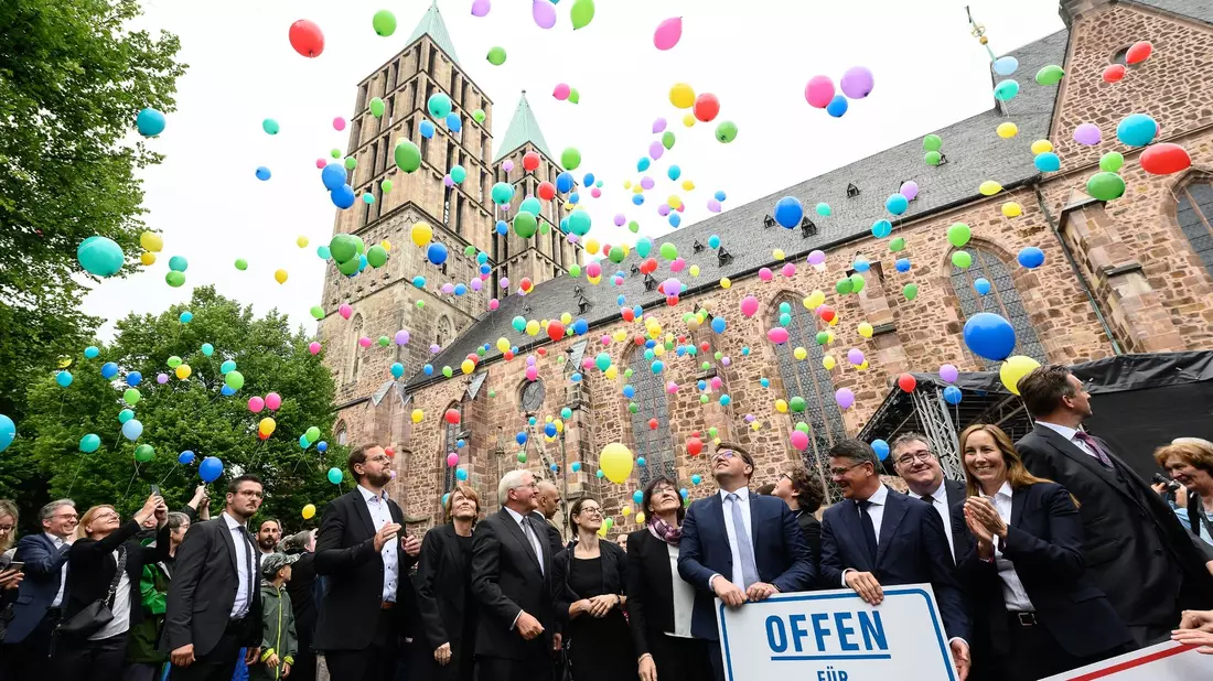 Bundespräsident Frank-Walter Steinmeier (M) lässt zusammen mit Gästen rund 500 Luftballons nach einer Gedenkfeier zum fünften Todestag von Walter Lübcke in den Himmel vor der Martinskirche in Kassel steigen. - Bild: Swen Pförtner/dpa