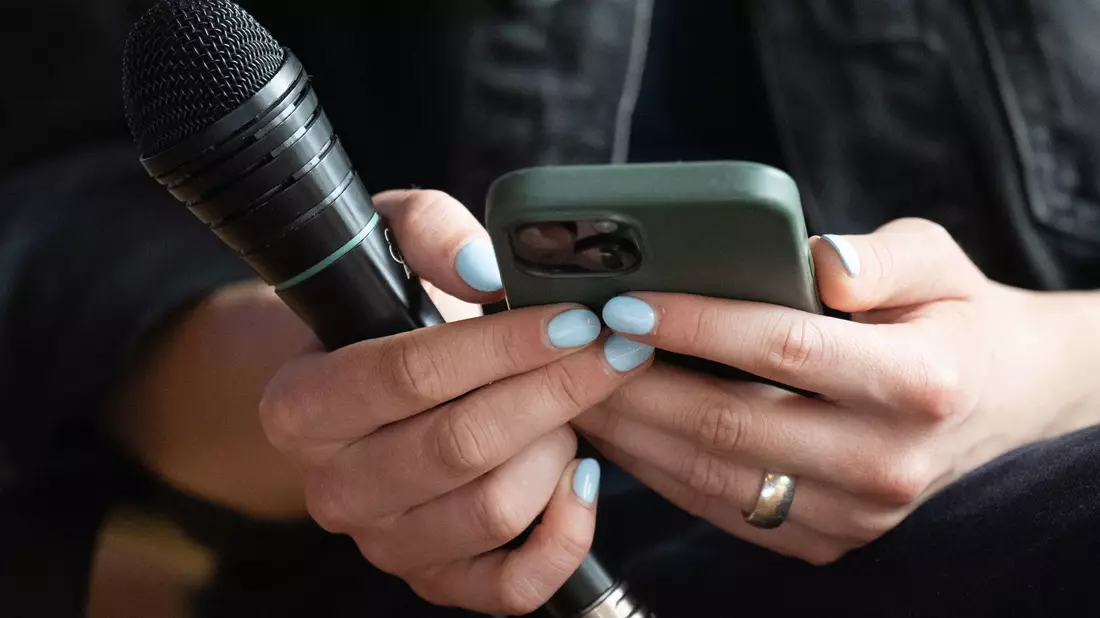 Klimaschutzaktivistin Luisa Neubauer liest auf dem Deutschen Katholikentag bei einer Podiumsdiskussion Hasskommentare von ihrem Smartphone vor. - Bild: Hendrik Schmidt/dpa