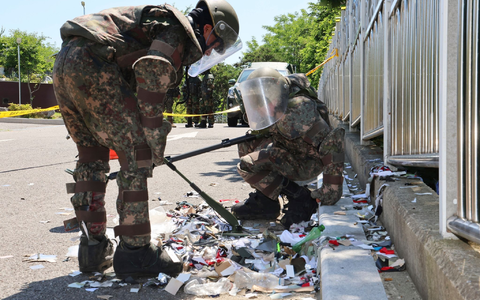 Südkoreanische Soldaten in Schutzkleidung untersuchen Müll aus einem aus Nordkorea entsandten Ballon. - Foto: Uncredited/YONHAP/AP/dpa