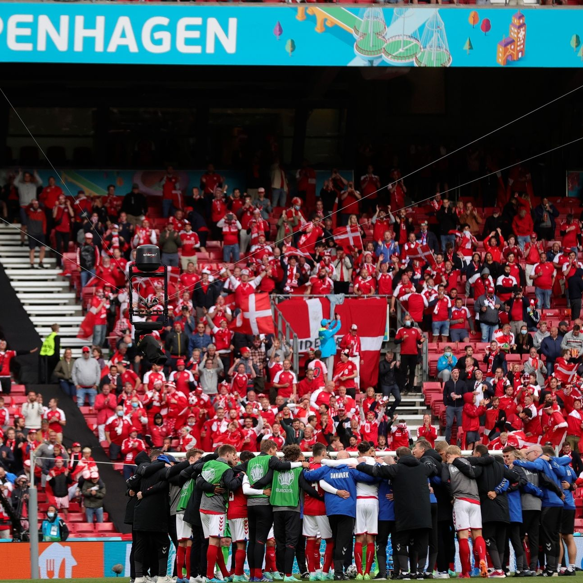 Die dänische Mannschaft schwört sich vor dem Wiederanpfiff ein. - Foto: Friedemann Vogel/POOL EPA/AP/dpa