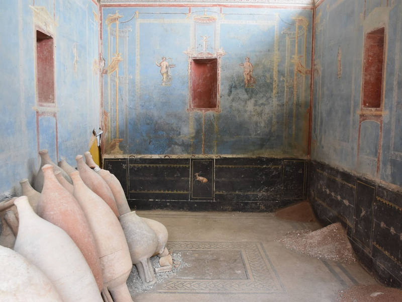 Ein Raum mit blauen Wänden und gemalten weiblichen Figuren ist in Pompeji freigelegt worden. - Foto: Archäologiepark Pompeji/dpa