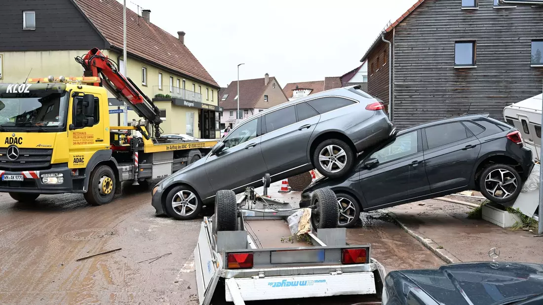 Auf einer Straße in Miedelsbach im Rems-Murr-Kreis (Baden-Württemnerg) stehen Fahrzeuge, die vom Hochwasser weggespült wurden. - Bild: Bernd Weißbrod/dpa