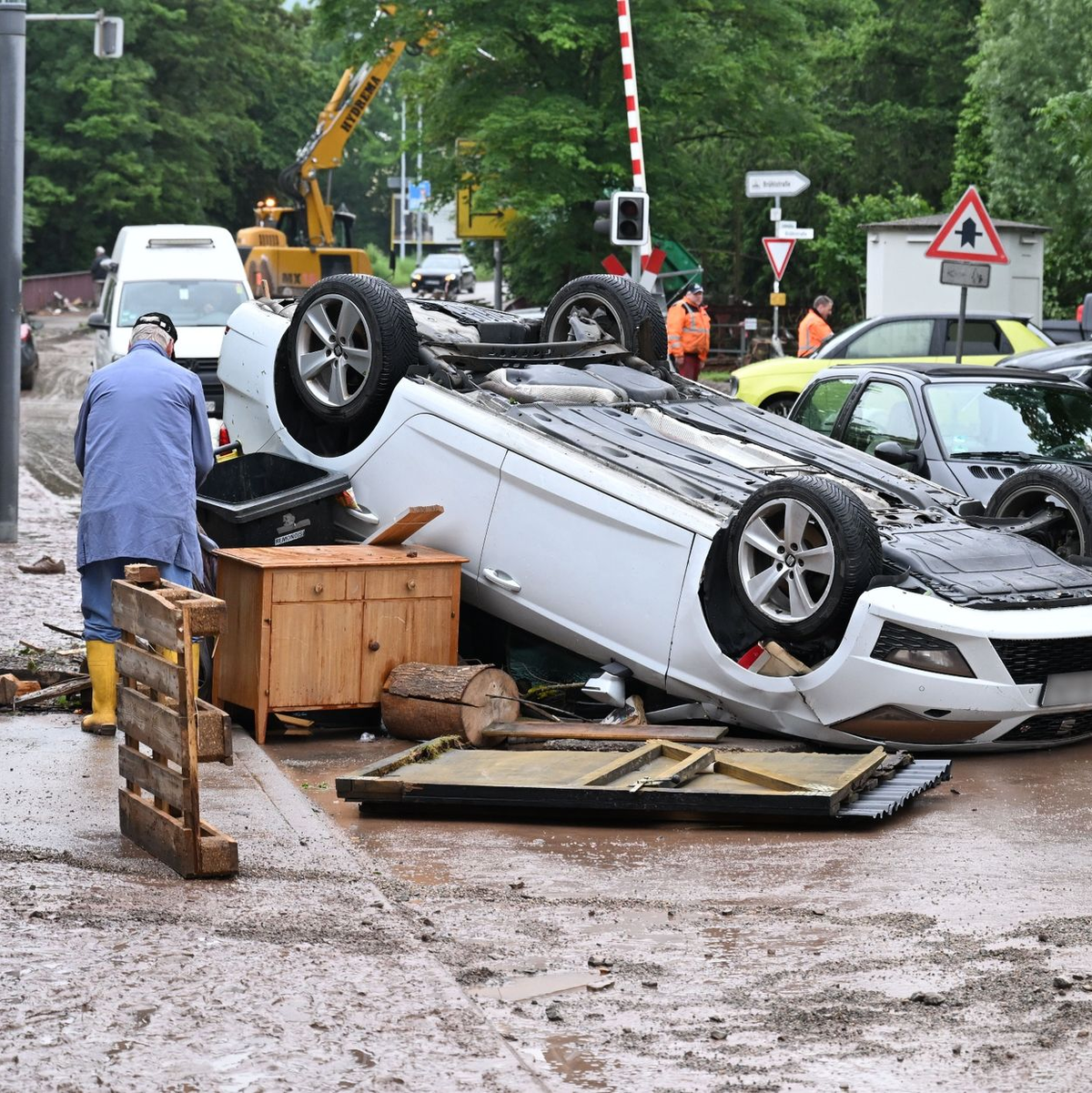 Auf einem Brunnen in Rudersberg steht ein durch Hochwasser weggespültes Auto. - Foto: Bernd Weißbrod/dpa