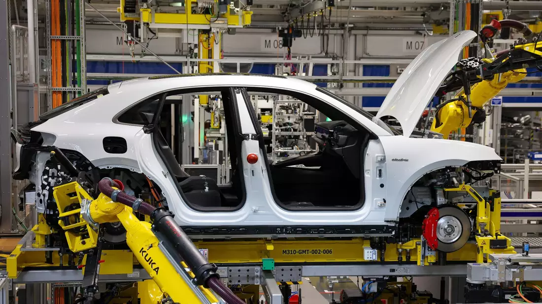 Industrieroboter arbeiten an einem vollelektrischen Porsche Macan. - Bild: Jan Woitas/dpa